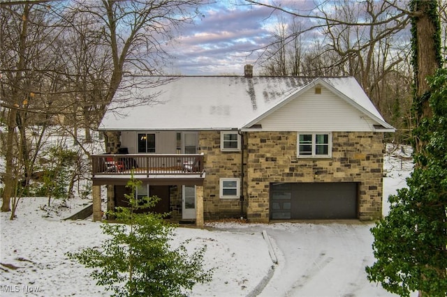 view of front of home with stone siding, a chimney, and an attached garage