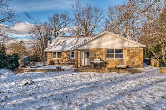 exterior space featuring stone siding and fence