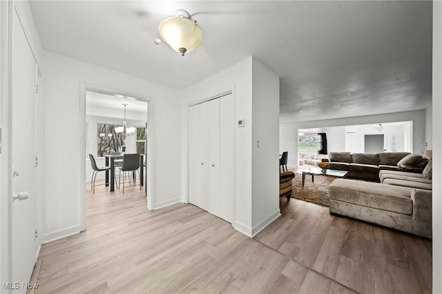 interior space with light hardwood / wood-style floors, a healthy amount of sunlight, and a notable chandelier