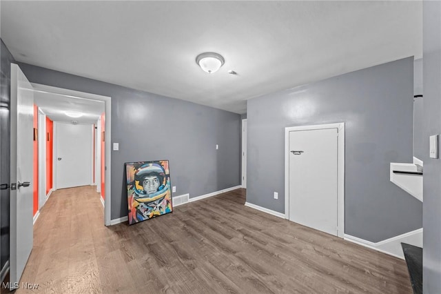 interior space featuring baseboards, visible vents, and wood finished floors