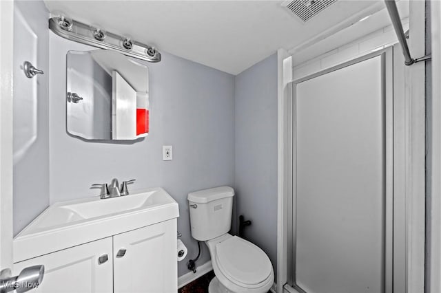 bathroom featuring vanity, toilet, and an enclosed shower