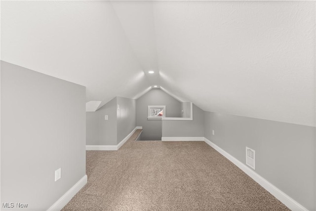 bonus room with carpet floors and vaulted ceiling