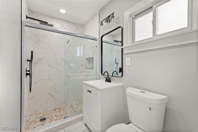 bathroom featuring tile patterned flooring, vanity, toilet, and walk in shower