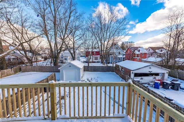 snow covered deck with an outbuilding and a garage