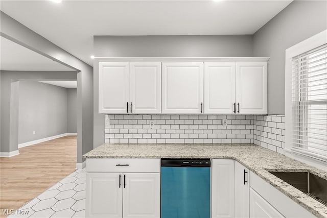 kitchen with white cabinets, dishwasher, light wood-type flooring, and tasteful backsplash