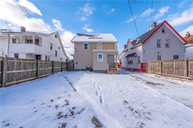 snow covered rear of property with central air condition unit