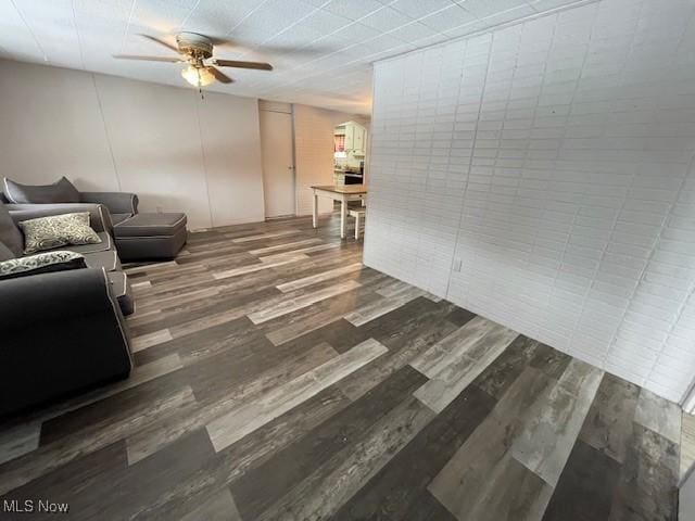 living room with ceiling fan and dark hardwood / wood-style flooring