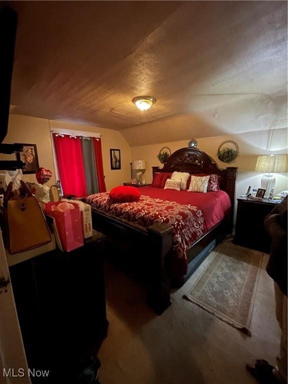 carpeted bedroom with a textured ceiling and lofted ceiling