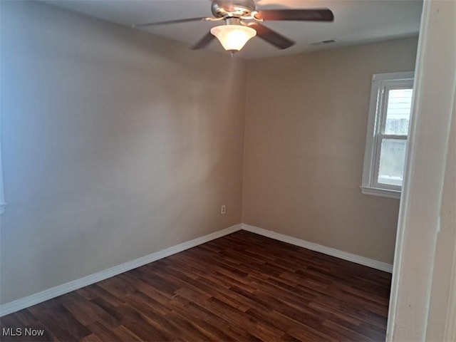 spare room featuring ceiling fan and dark wood-type flooring