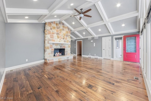 unfurnished living room with a fireplace, hardwood / wood-style floors, lofted ceiling with beams, and ceiling fan