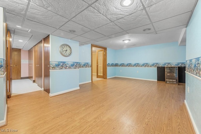 spare room with hardwood / wood-style floors and a drop ceiling