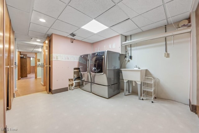 washroom with washer and dryer and sink