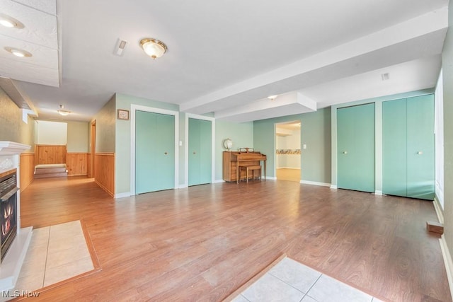 unfurnished living room with wood-type flooring and a baseboard radiator