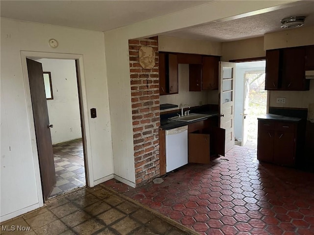 kitchen featuring white dishwasher, dark brown cabinets, sink, and exhaust hood