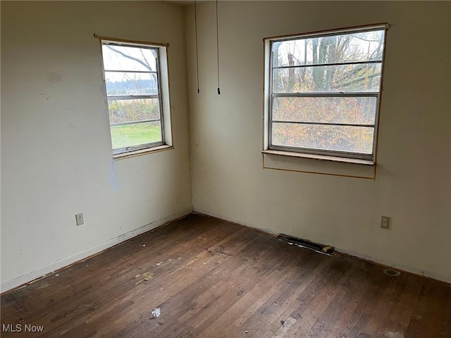 unfurnished room with dark wood-type flooring