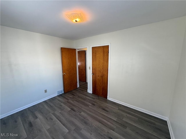 spare room with dark wood-type flooring