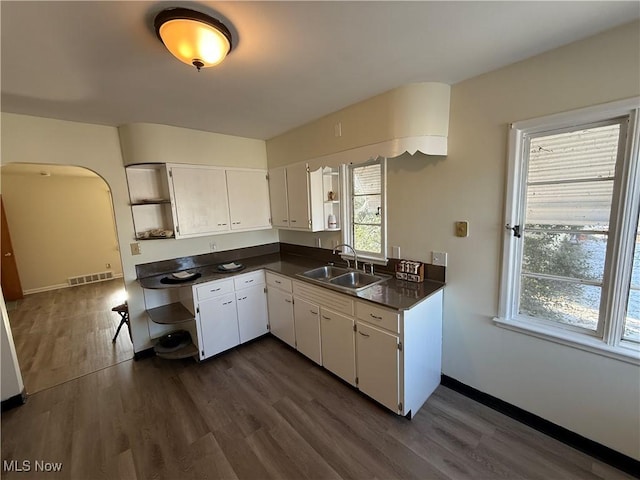 kitchen featuring sink, dark wood-type flooring, and white cabinetry