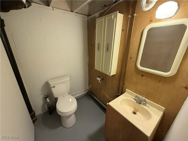 bathroom with toilet, concrete flooring, and vanity