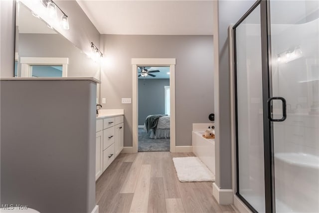 bathroom featuring wood-type flooring, vanity, separate shower and tub, and ceiling fan