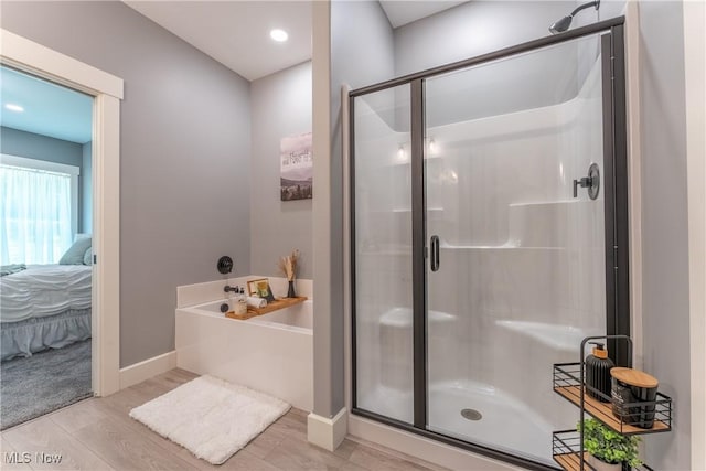 bathroom featuring hardwood / wood-style floors and independent shower and bath