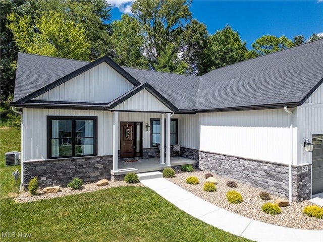 view of front of home with a front lawn, covered porch, and central AC