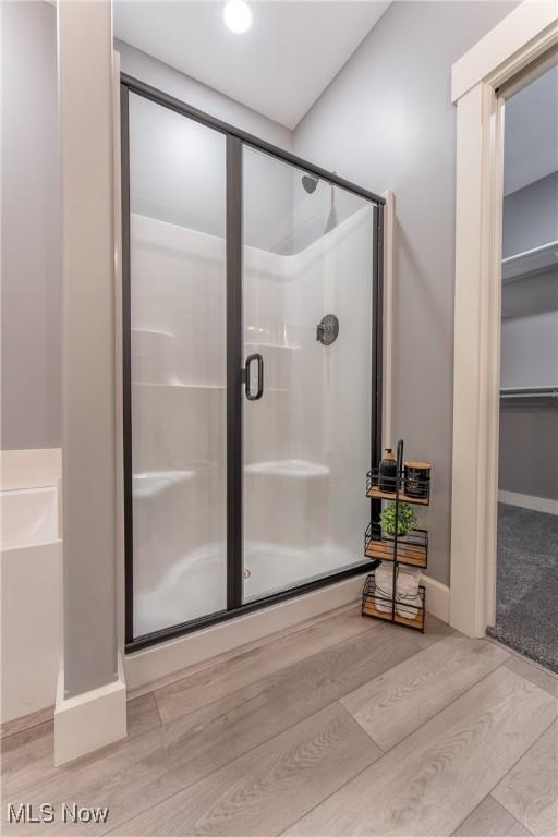 bathroom featuring wood-type flooring and walk in shower