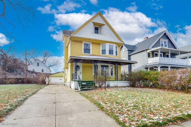 victorian home with a garage, covered porch, an outbuilding, and a front lawn