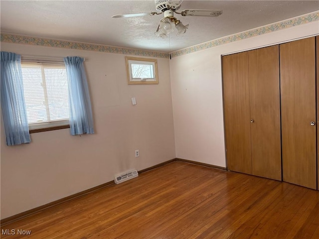 unfurnished bedroom featuring light hardwood / wood-style flooring, a closet, and ceiling fan