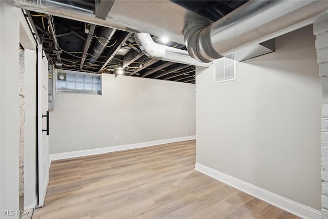 basement with light hardwood / wood-style floors