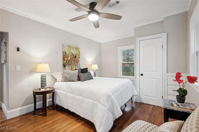 bedroom featuring ceiling fan, dark hardwood / wood-style floors, and ornamental molding