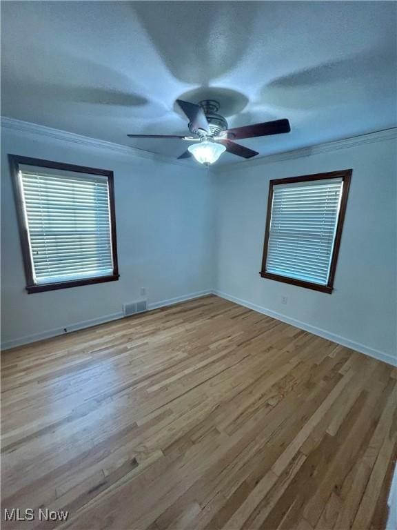 empty room featuring light hardwood / wood-style floors and ornamental molding