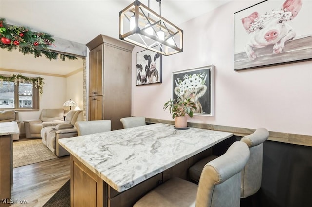 dining room with wood-type flooring and crown molding