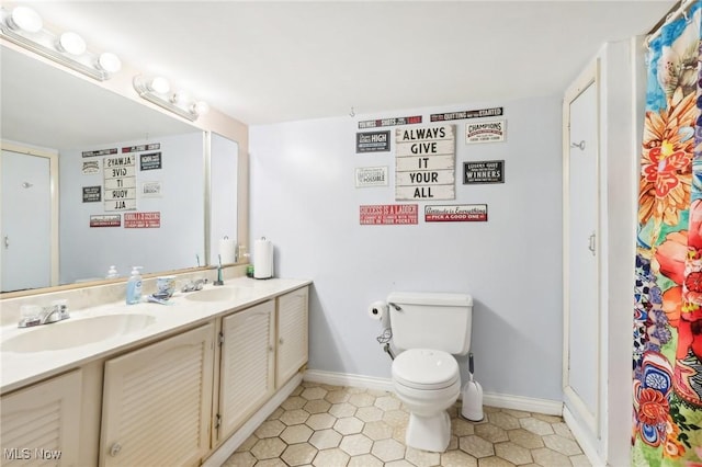 bathroom featuring tile patterned floors, vanity, and toilet