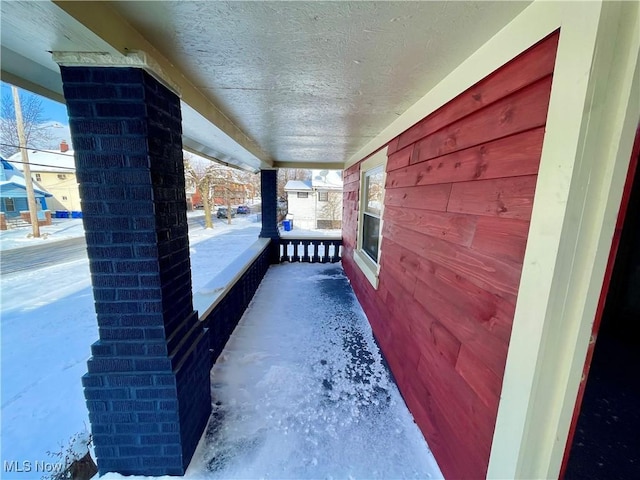 snow covered patio featuring a porch