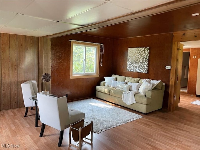 living room featuring light hardwood / wood-style floors and wooden walls