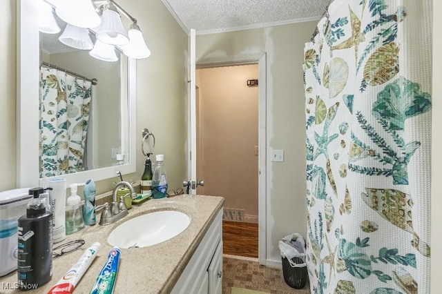 bathroom with vanity, a textured ceiling, and ornamental molding