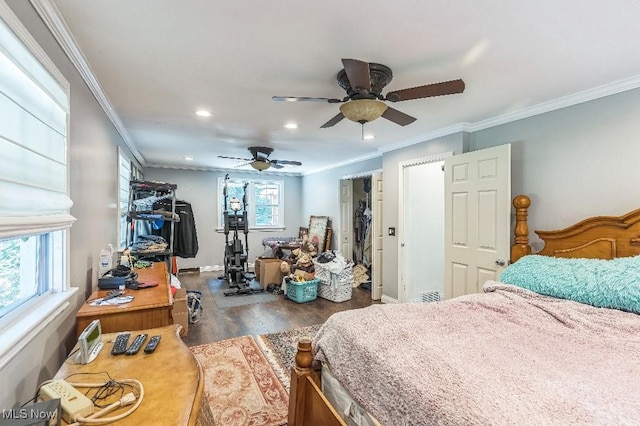 bedroom with ceiling fan, crown molding, dark wood-type flooring, and a closet