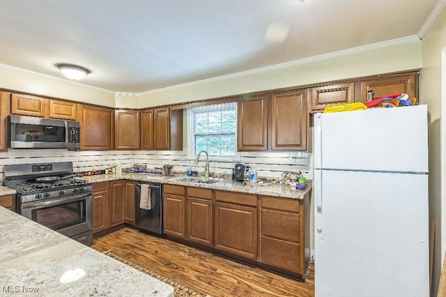 kitchen with decorative backsplash, appliances with stainless steel finishes, crown molding, dark wood-type flooring, and sink