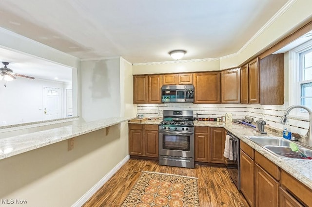 kitchen with sink, stainless steel appliances, dark hardwood / wood-style floors, backsplash, and crown molding