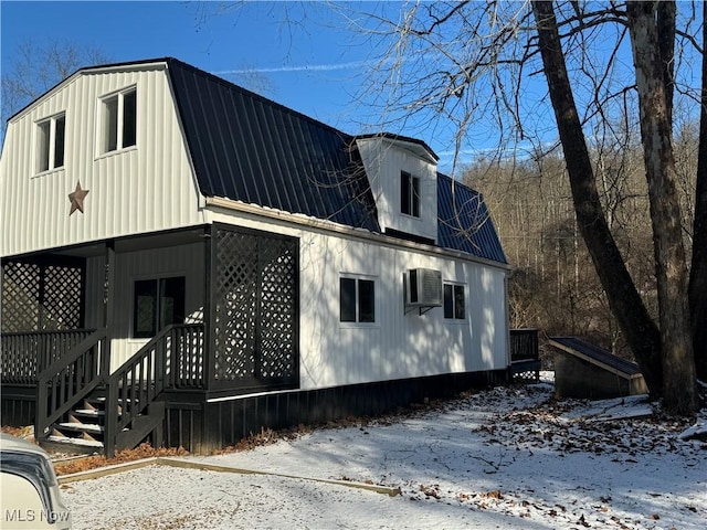 snow covered property with a wall mounted AC