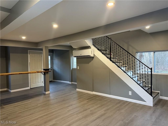 interior space with wood-type flooring and an AC wall unit