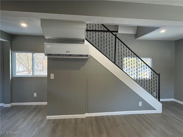 kitchen featuring hardwood / wood-style floors, plenty of natural light, and a wall mounted AC