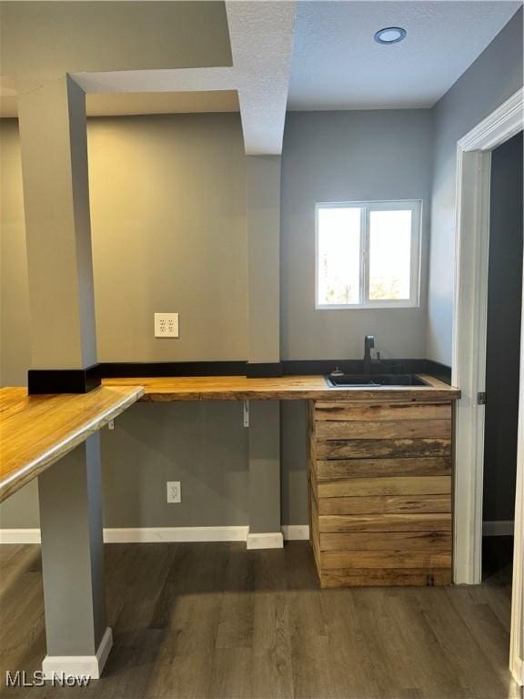 interior space featuring sink, built in desk, and dark hardwood / wood-style floors