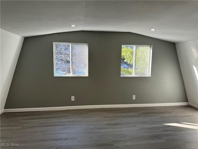 bonus room featuring a textured ceiling, hardwood / wood-style floors, and lofted ceiling