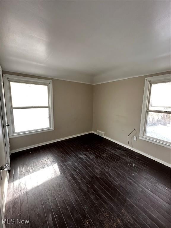 unfurnished room with a healthy amount of sunlight and dark hardwood / wood-style flooring