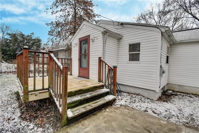 snow covered rear of property featuring a wooden deck