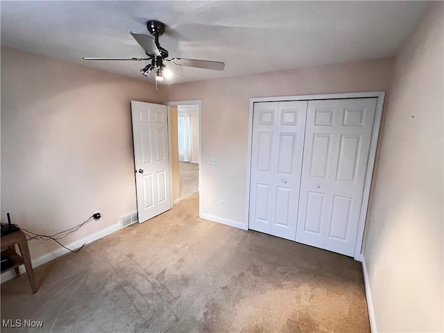 unfurnished bedroom featuring carpet flooring, ceiling fan, and a closet