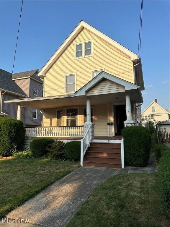 view of front of home featuring covered porch and a front yard