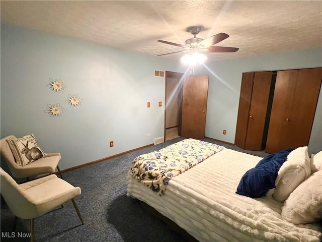 bedroom featuring ceiling fan, a closet, a textured ceiling, and dark colored carpet