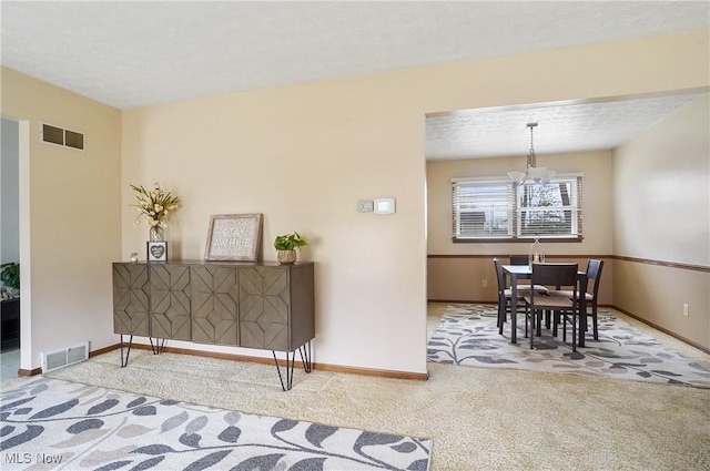 interior space with a notable chandelier, a textured ceiling, and carpet